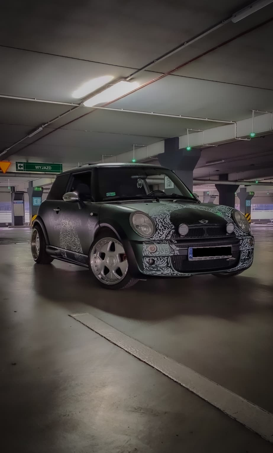 Mini v zeleni foliji z belim ornamentom v podzemni garaži