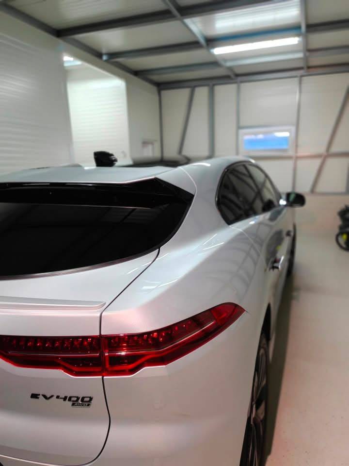 Srebrn Jaguar I-Pace v delavnici, pogled od zadaj
